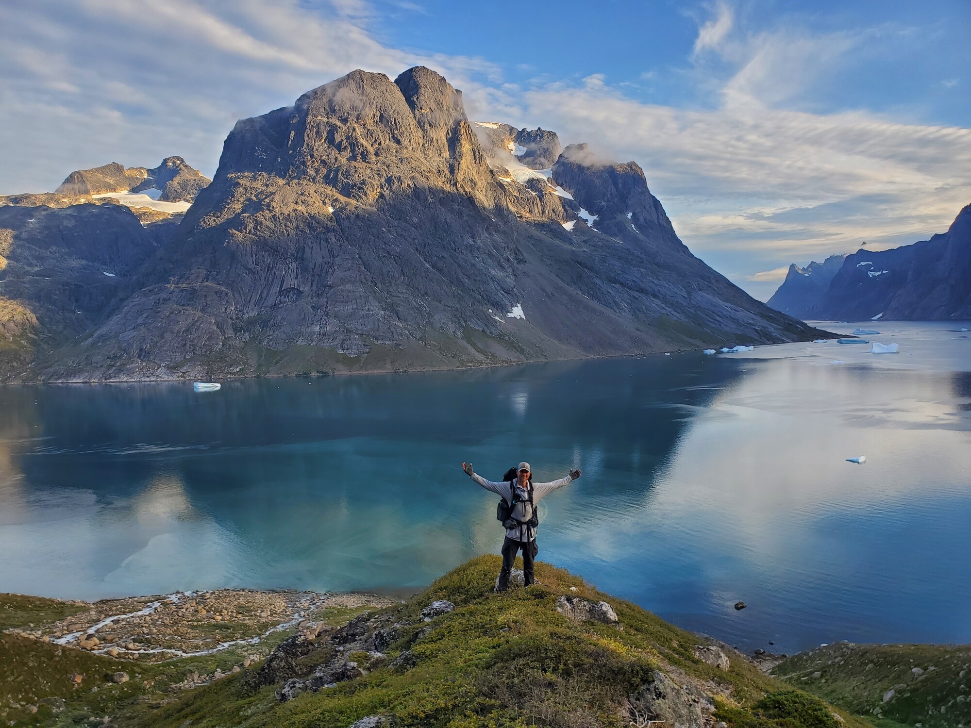 Een man op een hike door het zomerse fjordenlandschap van Groenland