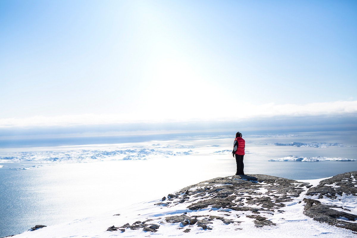 Een reiziger op een berg in de Nuuk fjord in Groenland