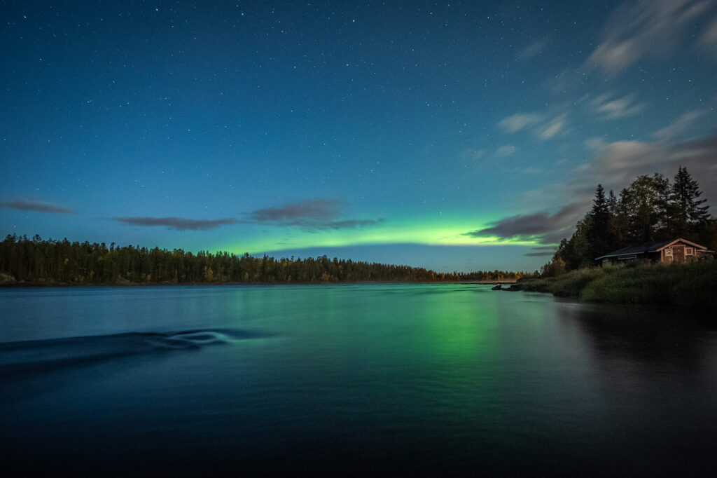 Het noorderlicht boven een rivier tijdens de herfst in Lapland